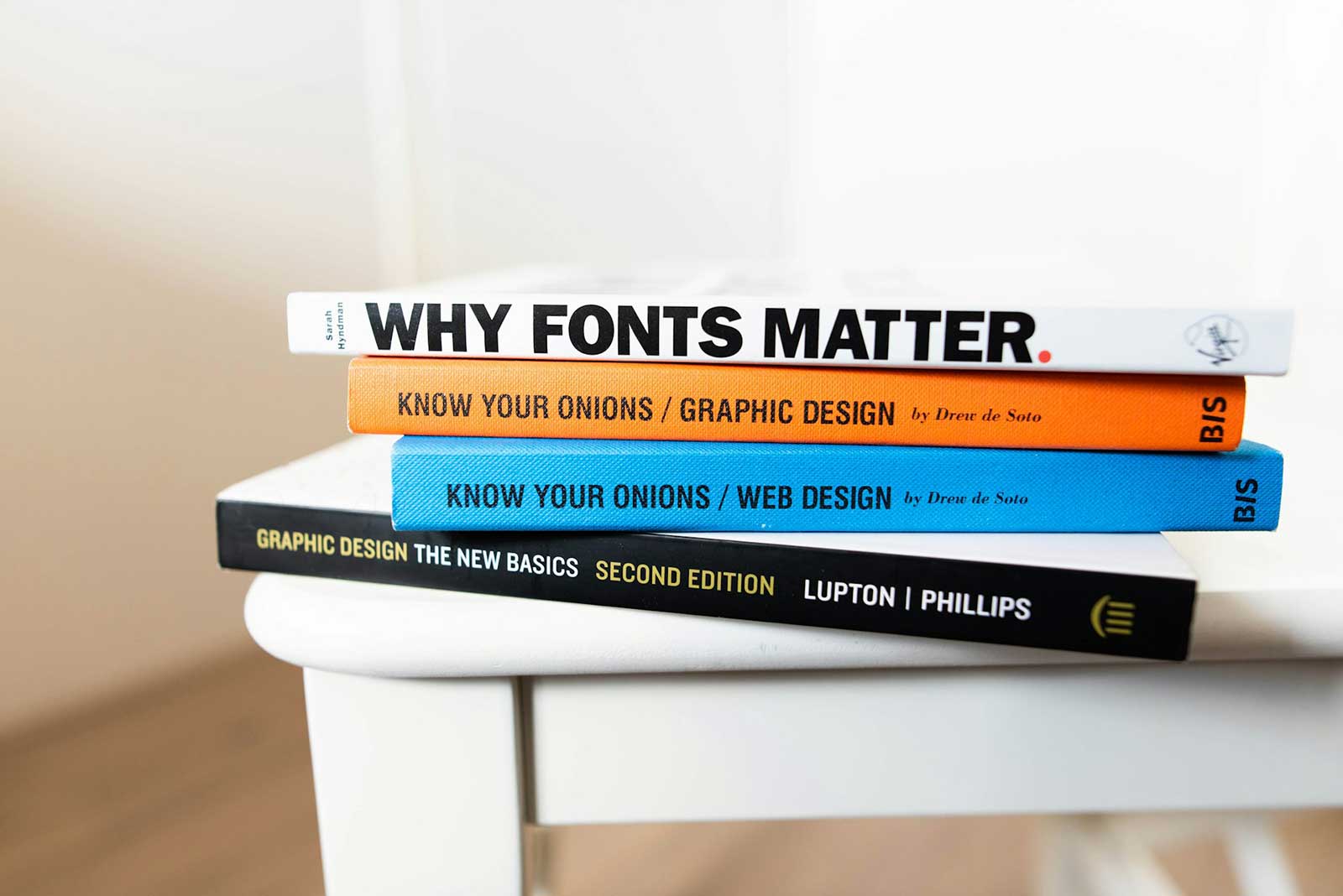 Stack of books about Graphic Design on small end table.